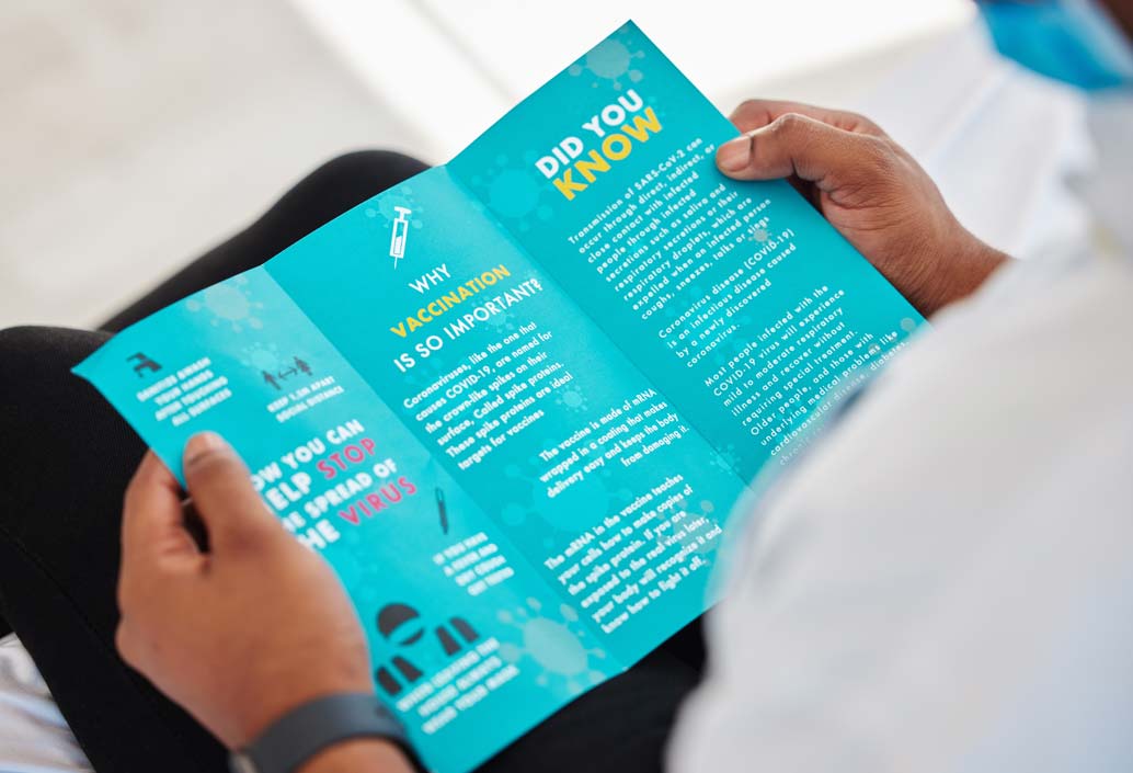 Person holding a full color tri-fold brochure