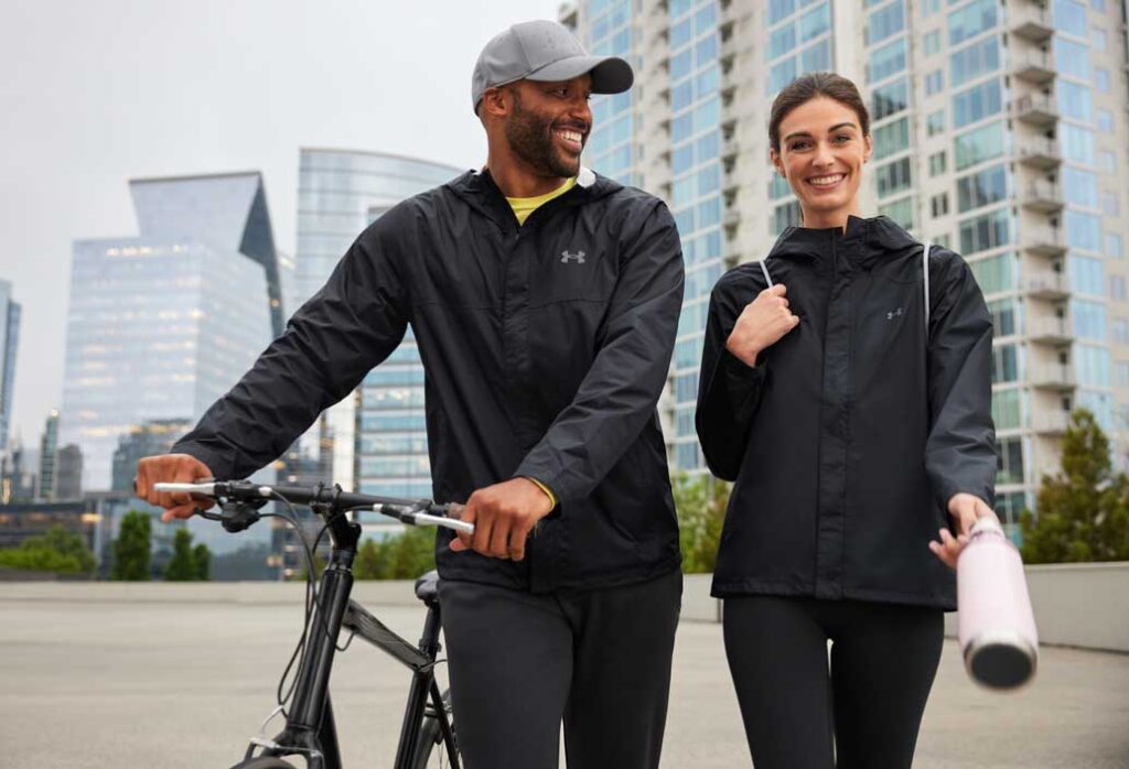 Active man and woman sporting Under Armour full zip and hoodie in the city