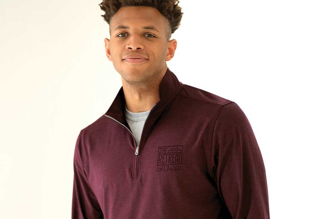 Man wearing a quarter zip that has tone on tone garment decoration